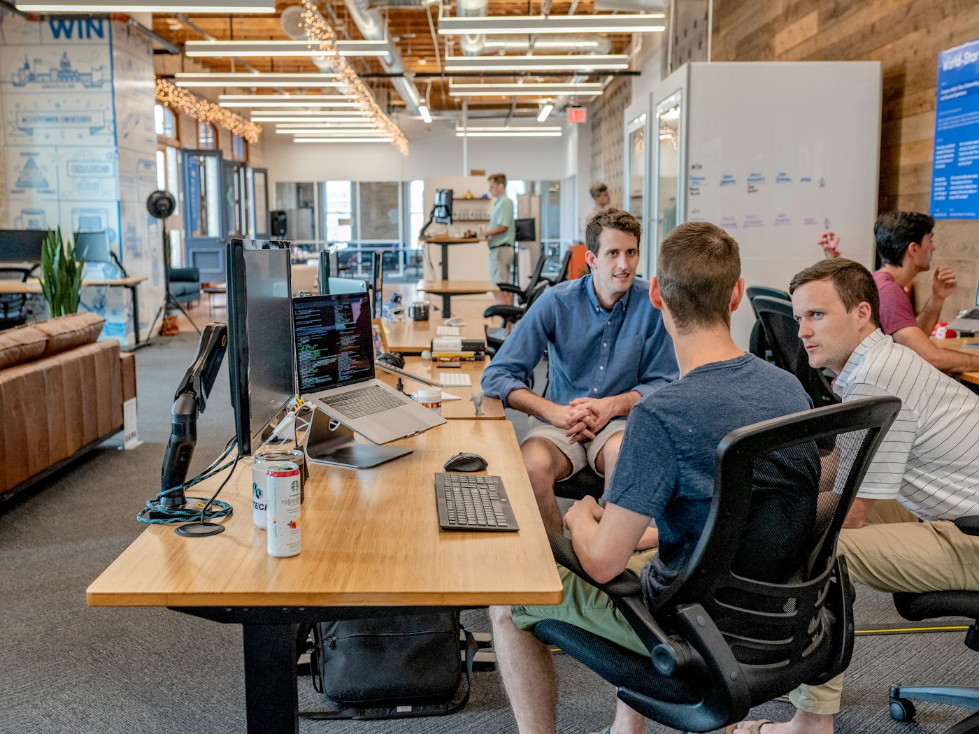 People working at desks with code on screen